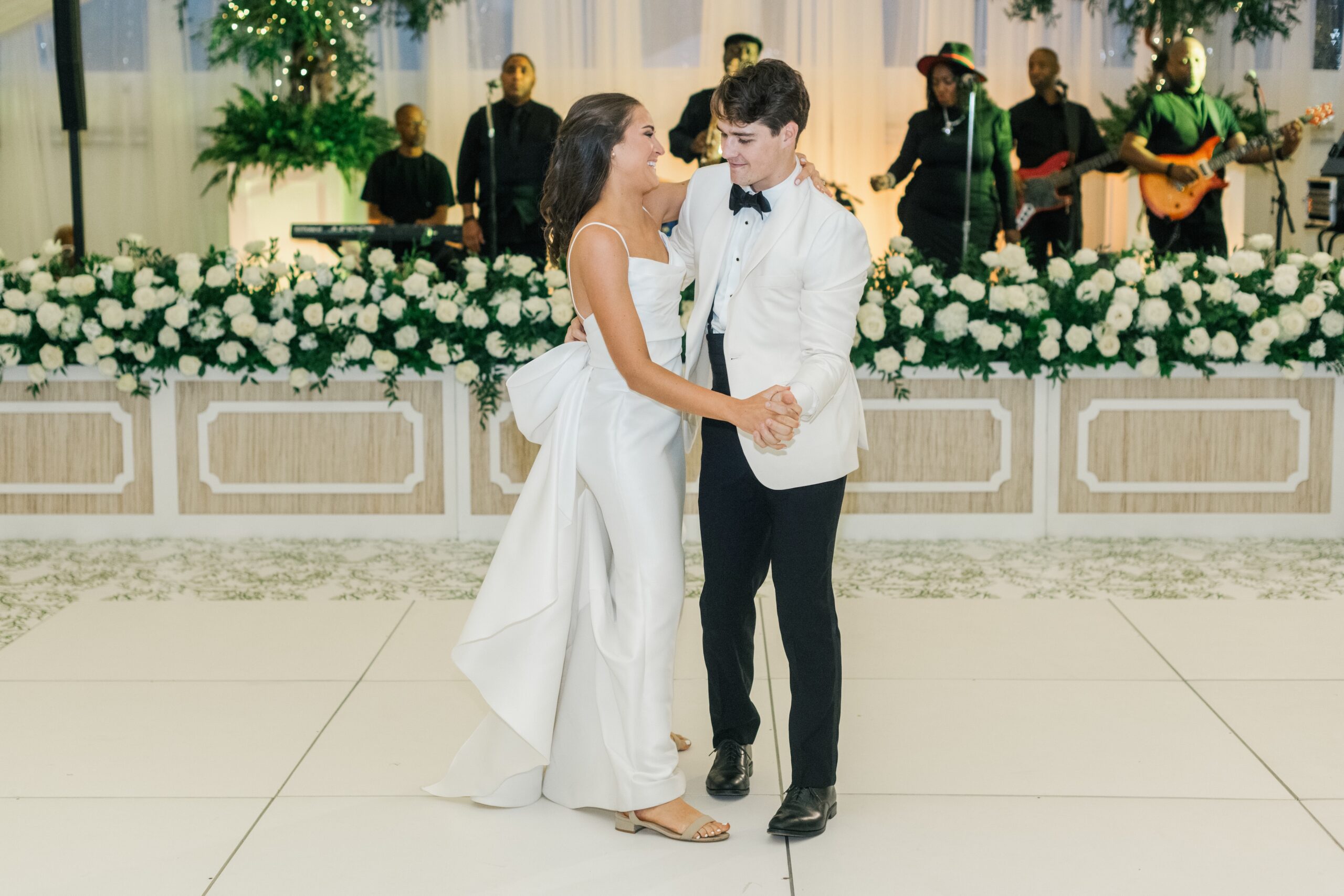 This photo is at a wedding with a couple on the dance floor dancing their first dance as husband and wife