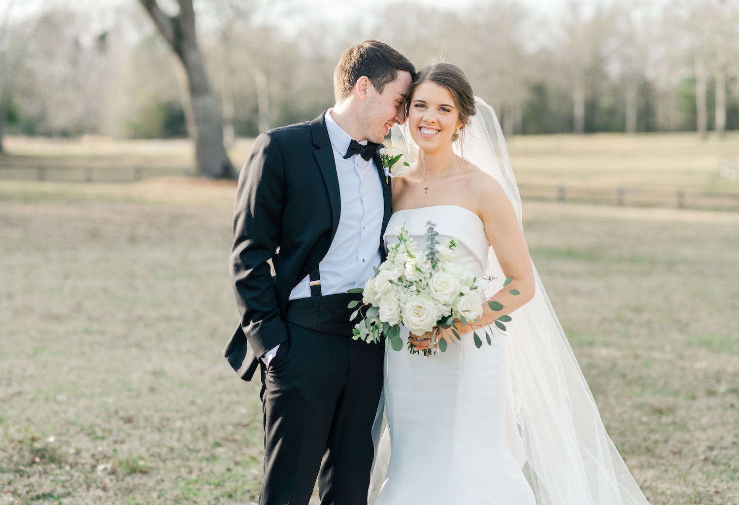 bride and groom standing in the "nuzzle" post on their wedding day