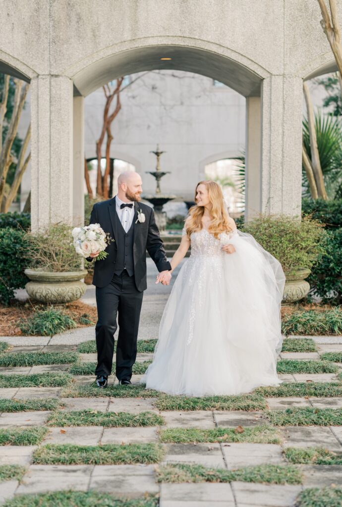 bride and groom walking for a portrait looking at each other