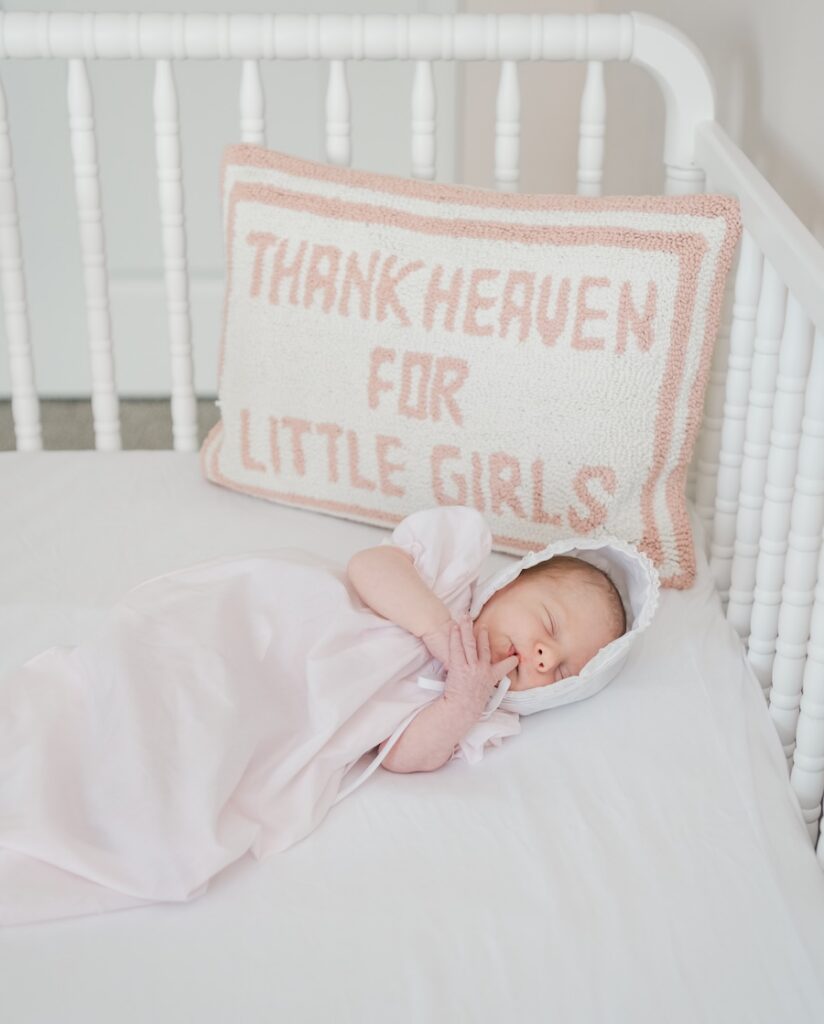 photo of newborn baby girl laying in crib asleep